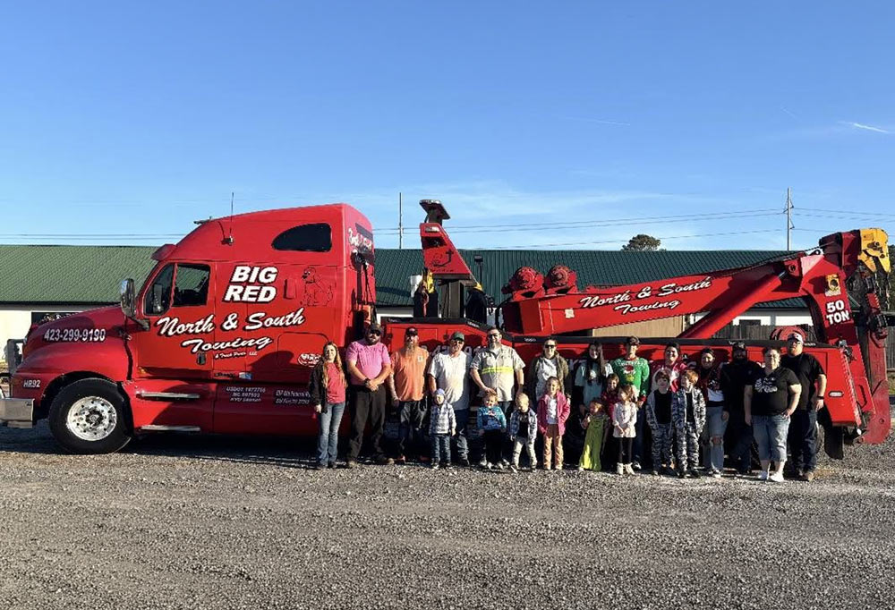 North and South Towing LLC Company Photo of crew members and family standing in front of heavy duty wrecker